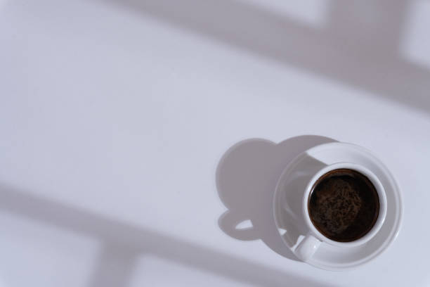 istock White office desk with a cup of coffee, shadows on the desk, workspace, copy space 1615652019