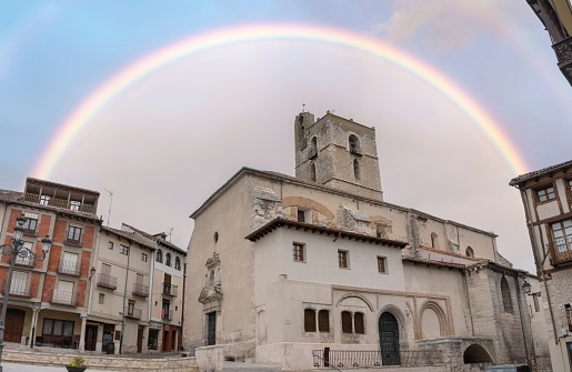 Cuellar, Spain – October 19, 2021: The Church of San Miguel of Romanesque origin under a rainbow in Segovia, Spain