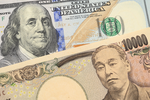 Closeup of US 100 dollar bill and Japanese 10000 yen banknote.