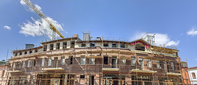 old red brick building under renovation. panoramic view in sunny summer day.