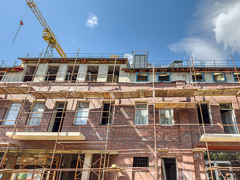 reconstruction of an old brick building. scaffolding on the facade. front view.