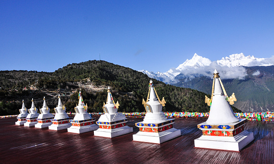 Tibetan Stupas (praying place) with Meili snow mountain background in Yunnan, China. Meili Snow Mountains is one of the most sacred mountains of Tibetan Buddhism.