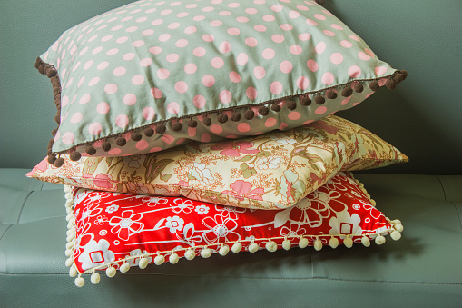 Three cushions decorated with pendulums on the sofa