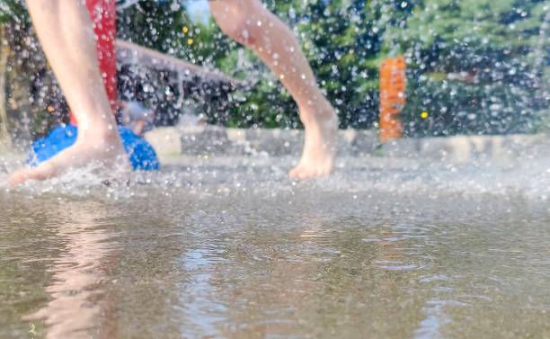 in hot summer, kids runing on the splash pad playground.