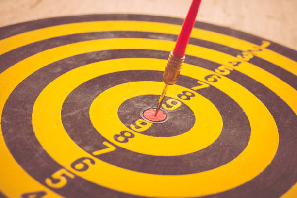 Red dart arrow hitting on center of dartboard. Business target and strategy, success investment concept.