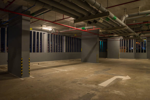 istock Parking garage interior in building at night with warm lighting. 1615735289