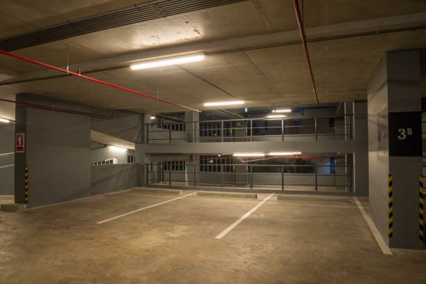 istock Parking garage interior in building at night with warm lighting. 1615735290