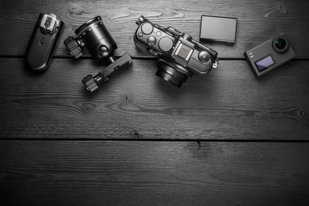 istock Digital compact and action cameras and equipment on black wooden plank table. top view. 1615775304