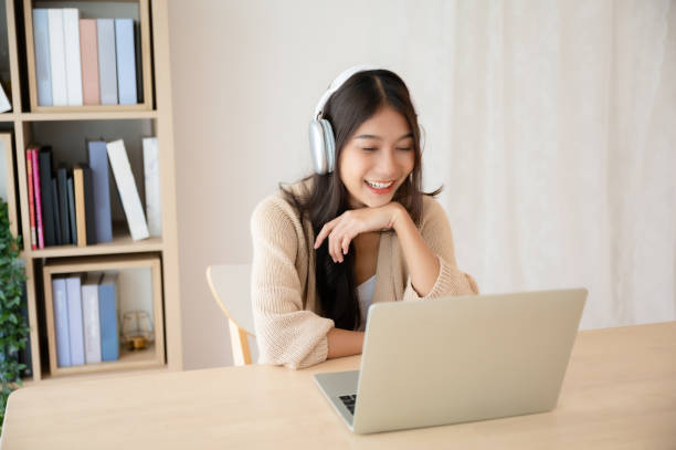 istock Young asian woman wearing headset while working on computer laptop at house. Work at home, Video conference, Video call, Student learning online class 1615791152