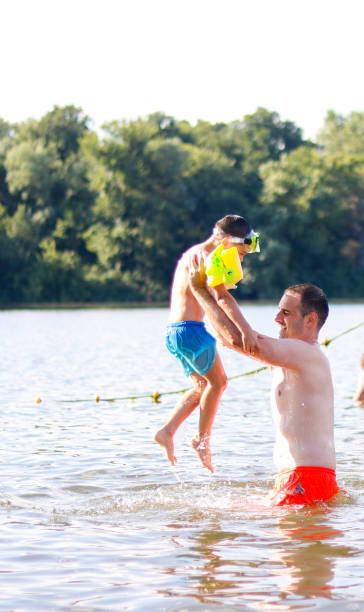 istock Father and son play in the water on vacation 1615803211