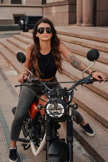 великолепная женщина на старинном мотоцикле - motorcycle women tattoo sensuality стоковые фото и изображения