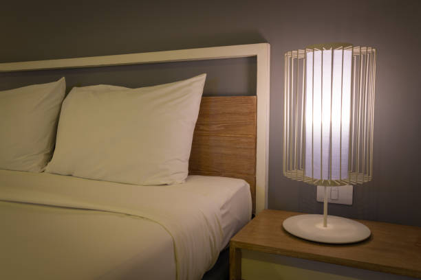 istock Bedroom with lamp lighting bedside table at night. 1615821698