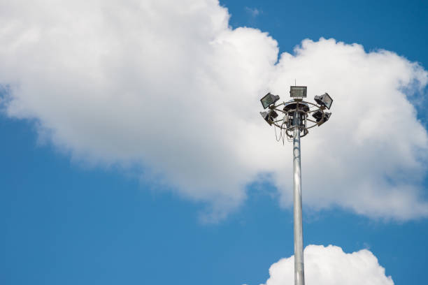 на открытом воздухе высокая прожекторная башня в общественном парке в дневное время. - floodlight blue sky day стоковые фото и изображения