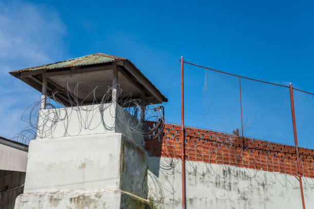 istock Prison or jail tower with barbed wire restricted area. 1615849793