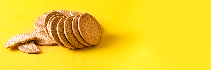 Marie biscuits cookies on bright yellow background for banner.Copy space