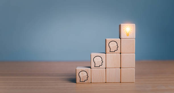 istock brainstorming creative idea and innovation. Hand putting over wooden cube block with light bulb icon on many people together having an idea symbolized by icons on cubes. 1615880143