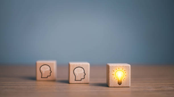 istock brainstorming creative idea and innovation. Hand putting over wooden cube block with light bulb icon on many people together having an idea symbolized by icons on cubes. 1615881756