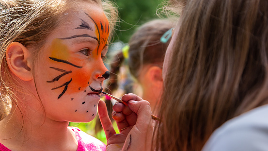 Painting children's faces during a family picnic.