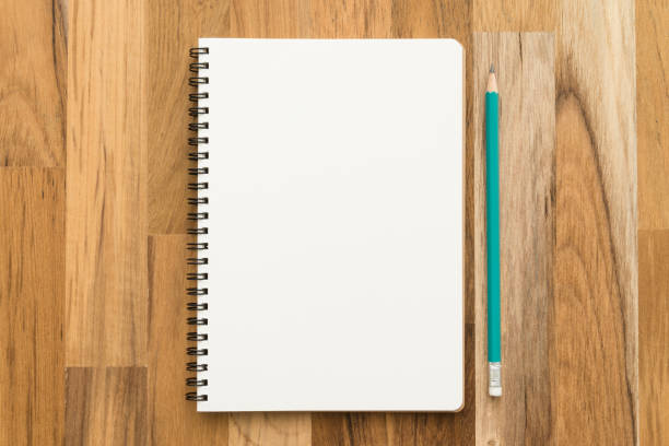 istock Flat lay of open blank spiral notepad or notebook and pencil on wooden table background. 1615899601