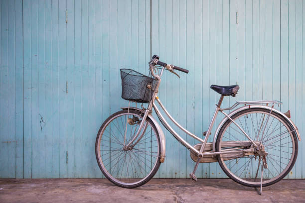 istock Vintage basket bicycle with old blue wooden wall background. 1615935135