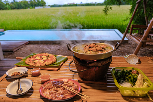 Thai Korean bbq with a look over green rice fields at a homestay at a farm in Thailand