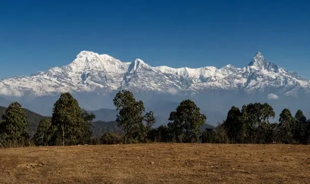 Annapurna Himalayan range panoramic viewpoint in  Nepal, during a clear sunny day with blue skies.