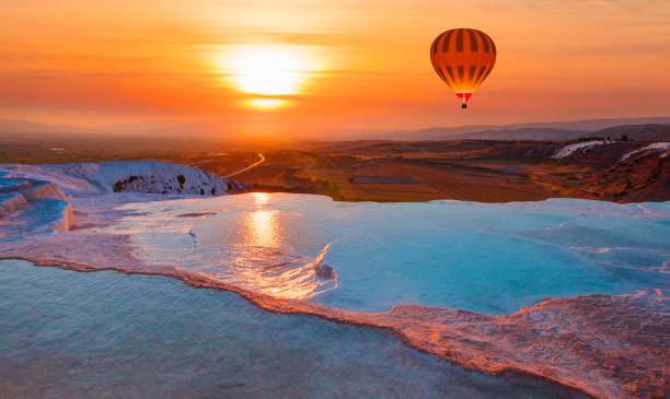 Hot air balloon flying over spectacular pamukkale - Natural travertine pools and terraces in Pamukkale. Cotton castle in southwestern Turkey Hot air balloon flying over spectacular pamukkale - Natural travertine pools and terraces in Pamukkale. Cotton castle in southwestern Turkey denizli stock pictures, royalty-free photos & images