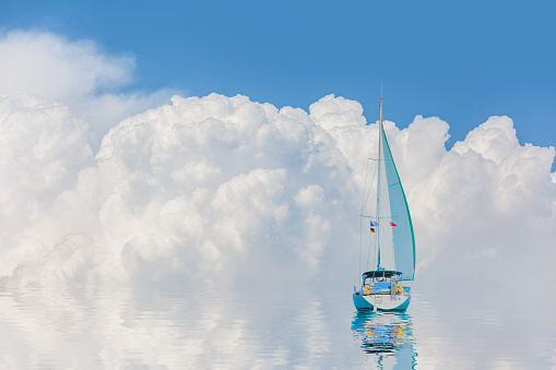 A white sailing yacht (boat) on the calm sea with storm clouds