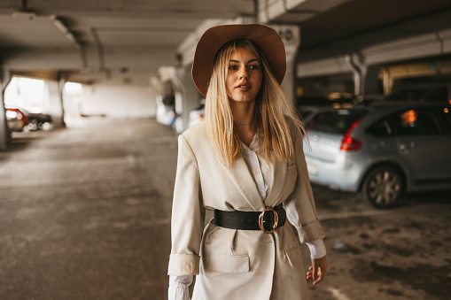 Elegant young woman walking on mall parking lot
