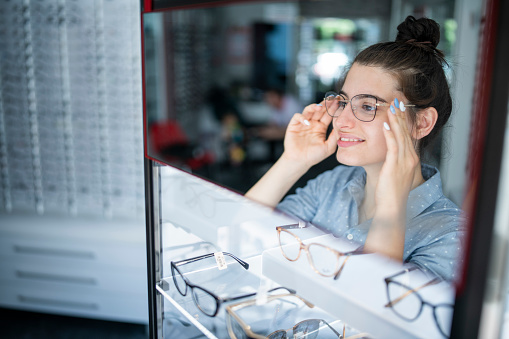 Woman with different glasses on light background, closeup