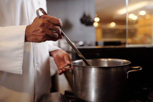 istock Cook Putting Soup in Plates 1616037189
