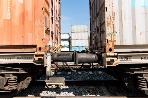 A collection of industrial containers lines the railway tracks, creating a dynamic scene that embodies the essence of commerce and transportation. These large metal structures, each with its unique purpose, form a bustling ecosystem of trade and logistics.