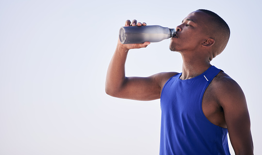Fitness, black man and drinking water outdoor for training, running and morning cardio on mockup background. Exercise, break and African male runner with drink for hydration, health and workout run