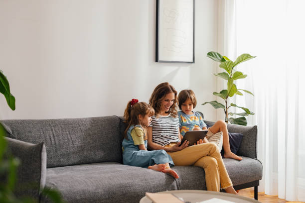 istock Mother Sitting With Her Kids and Watching Something on the Digital Tablet 1616062550