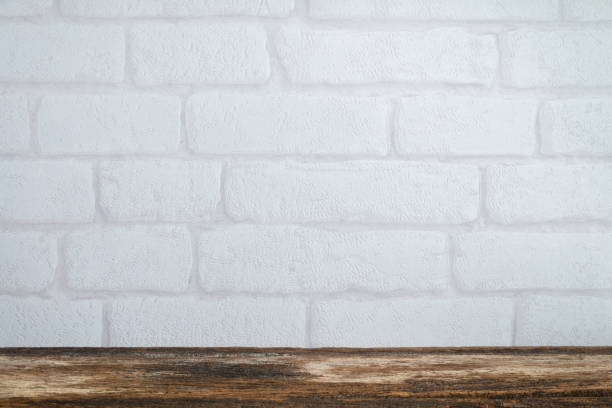 istock White brick wallpaper background with old wooden table with copy space. 1616067580