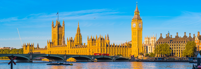 Panoramic view across the River Thames past the Westminster Bridge to Big Ben and the Houses of Parliament in the heart of London, UK.