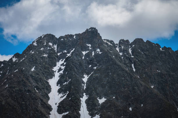 close up, snowy mountain with bright blue sky and white cloud. big mountain peak covered with snow - montana us glacier national park usa glacier imagens e fotografias de stock