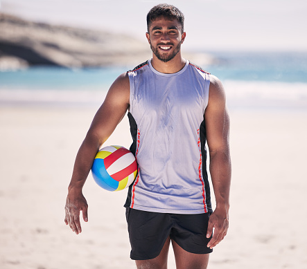 Beach, sports and portrait of man with volleyball for training, exercise and morning cardio in nature. Ocean, games and happy face of male player smile at sea for fun, fitness and workout performance