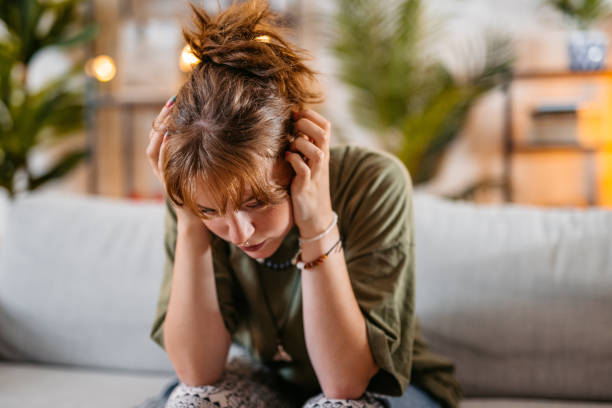 istock Sad Young Woman Sitting On The Sofa At Home 1616117155