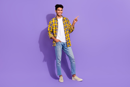 Full body photo of nice positive man put hand pocket indicate finger empty space isolated on violet color background.