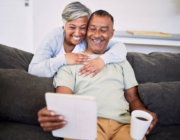istock Video call, happy and senior couple with a tablet on a sofa while relaxing and bonding together. Smile, love and elderly man and woman in retirement on a virtual conversation with digital technology. 1616155642