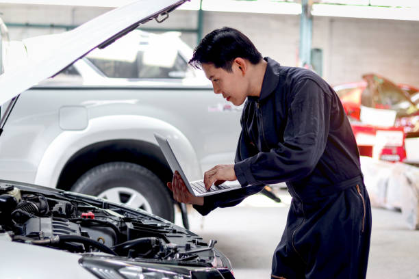 istock Asian mechanic man in uniform holding laptop computer during working with engine vehicle, auto mechanic technician inspecting maintenance customer car automobile at garage car repair service workshop. 1616157360