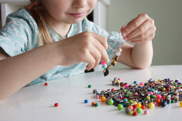 istock Process of making a bracelet from a thread and colored beads, concept of hobby 1616179170
