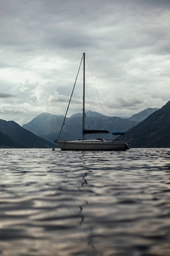 Photo of a sailing boat in the bay in cloudy weather