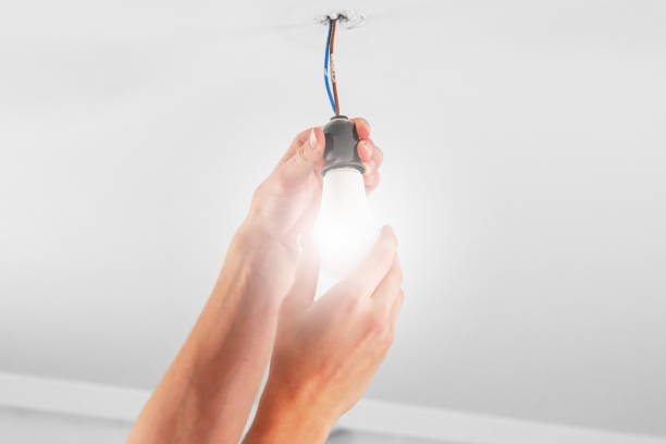 istock Replacing an glowing electrical energy saving white light bulb. Conceptual view 1616195556