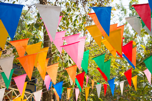 Colorful bunting banner garland triangle shape in outdoors summer festival. Festival, feast, party celebration concept.