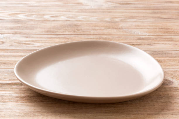 istock Perspective view of empty pink plate on wooden background. Empty space for your design 1616231493