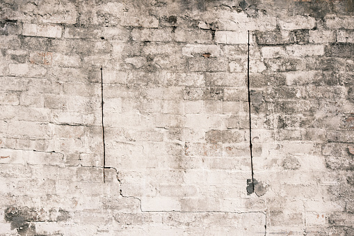 Section of an old dirty brick wall with two cut lines.