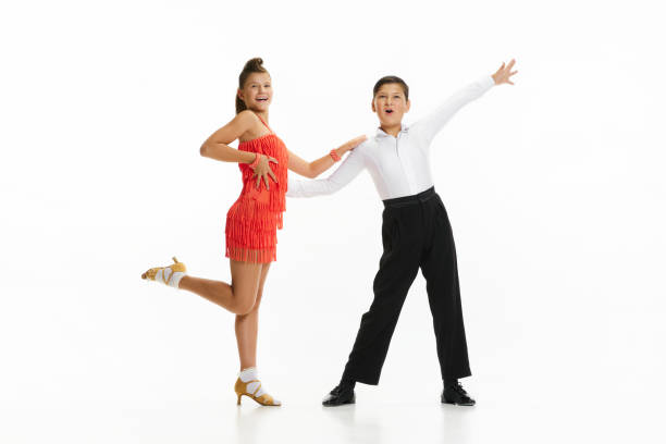 Stylish, beautiful children, boy and girl in stylish stage costumes dancing lindy hop against white studio background Stylish, beautiful children, boy and girl in stylish stage costumes dancing lindy hop against white studio background. Concept of childhood, hobby, active lifestyle, performance, art, fashion rockabilly boys stock pictures, royalty-free photos & images