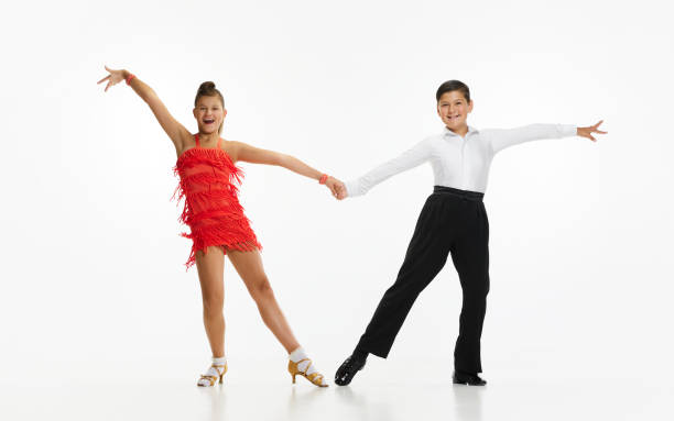 Talented, beautiful, artistic children, boy and girl in stage costumes dancing retro style dance against white studio background Talented, beautiful, artistic children, boy and girl in stage costumes dancing retro style dance over white studio background. Concept of childhood, hobby, active lifestyle, performance, art, fashion rockabilly boys stock pictures, royalty-free photos & images